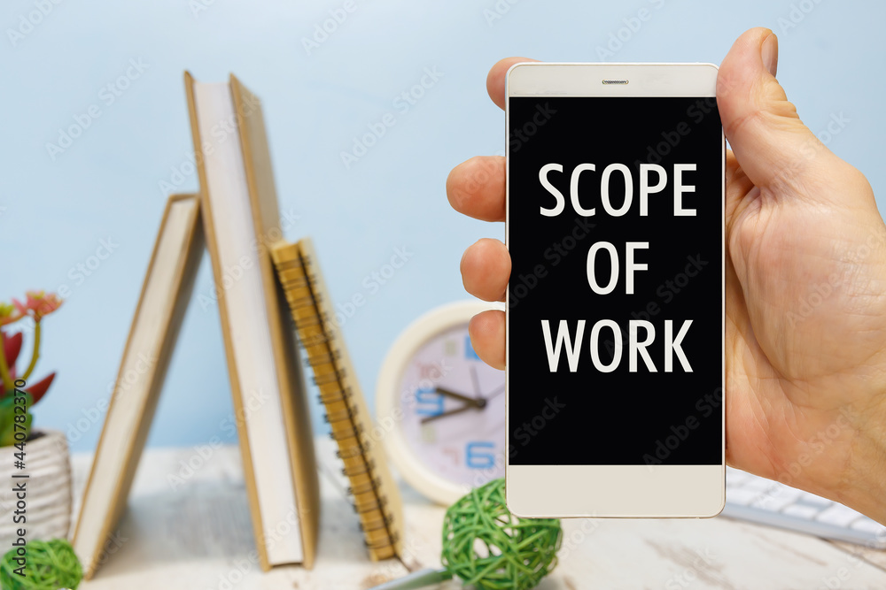Smartphone in hand with the inscription Scope of Work Smartphone in hand with the inscription Scope of Work