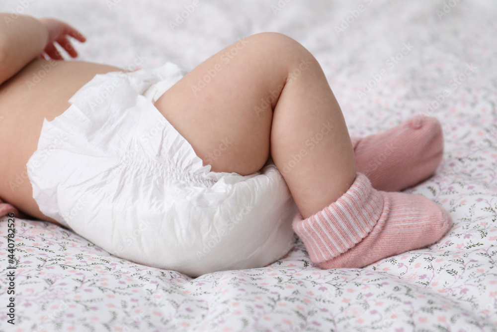 Little baby in diaper on bed, closeup Little baby in diaper on bed, closeup