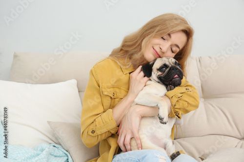 Woman with cute pug dog at home. Animal adoption © New Africa