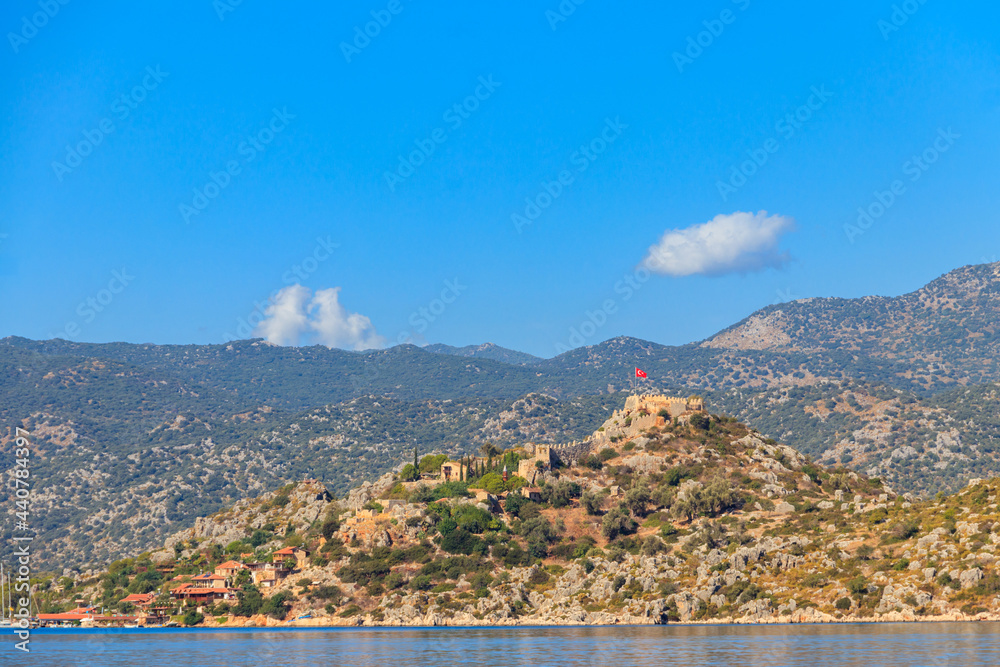 View of ancient Lycian town Simena with fortress on a mount on the coast of the Mediterranean sea in Antalya Province, Turkey