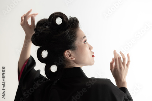 Portrait of young beautiful Japanese, woman in national attire kimono posing isolated over white studio background. photo