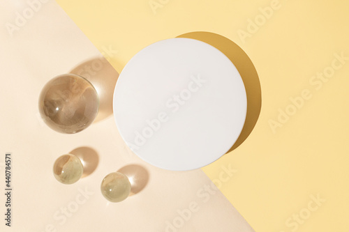 Top view of the blank white cosmetics box on the dual pastel background.Glass sphers near it,concept of the cleanness and clarity.Cosmetic mockup with copy space. photo