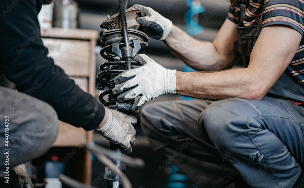 Stockfoto med beskrivningen spring replacement car suspension repair in the  garage. | Adobe Stock