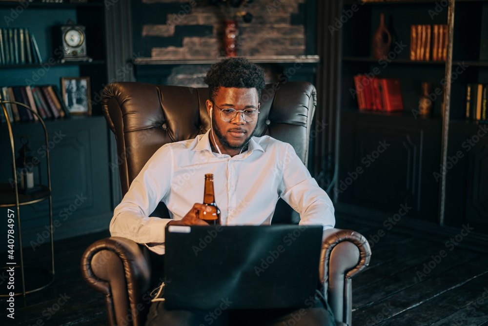 young attractive and happy successful black African American man networking with laptop computer at living room armchair