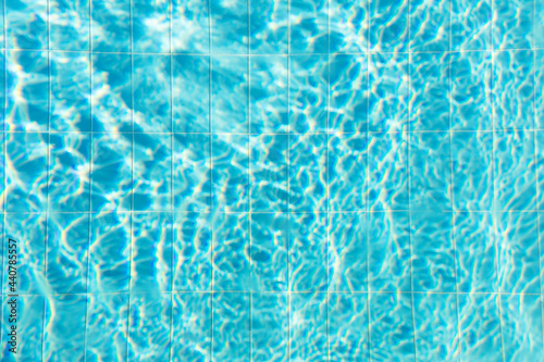 Blue ripped water with waves and rays in the swimming pool Summer vacation Background. Top view Copy space.