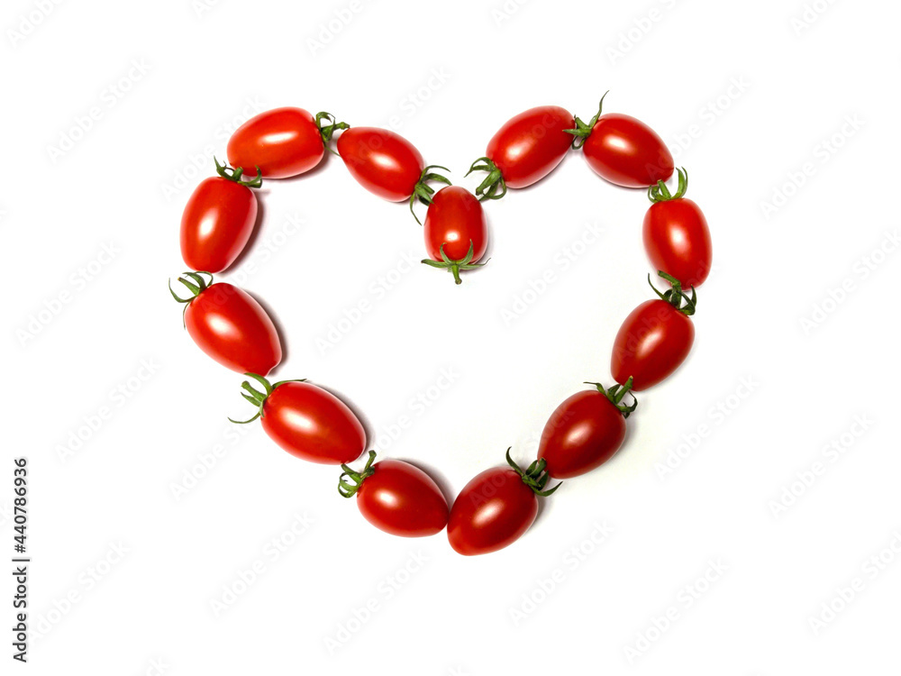 cherry tomatoes in the shape of a heart on white background