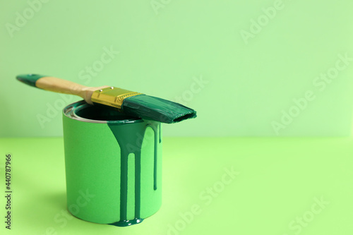 Fototapeta Naklejka Na Ścianę i Meble -  Can of green paint with brush on color background. Space for text