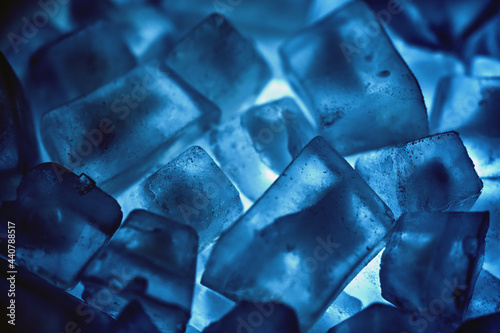 Frozen ice cubes on the dark blue light.