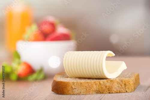 Slice of bread with butter on a kitchen desk.