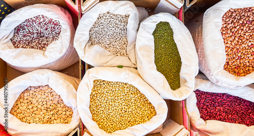 Different types of beans of various colors and lupins in sacks for sale in bulk at a local flea market
