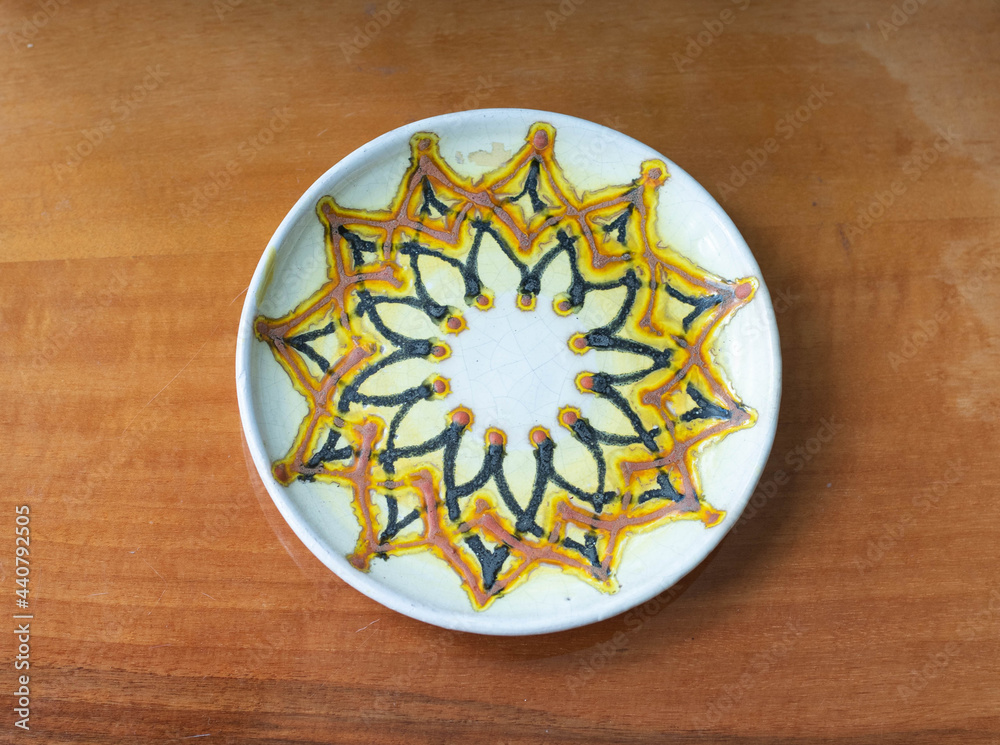 Mid-century modern ceramic plate with flower pattern on a wooden table