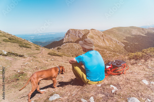 Outsanding mountain view and hiker with his vizsla dog photo