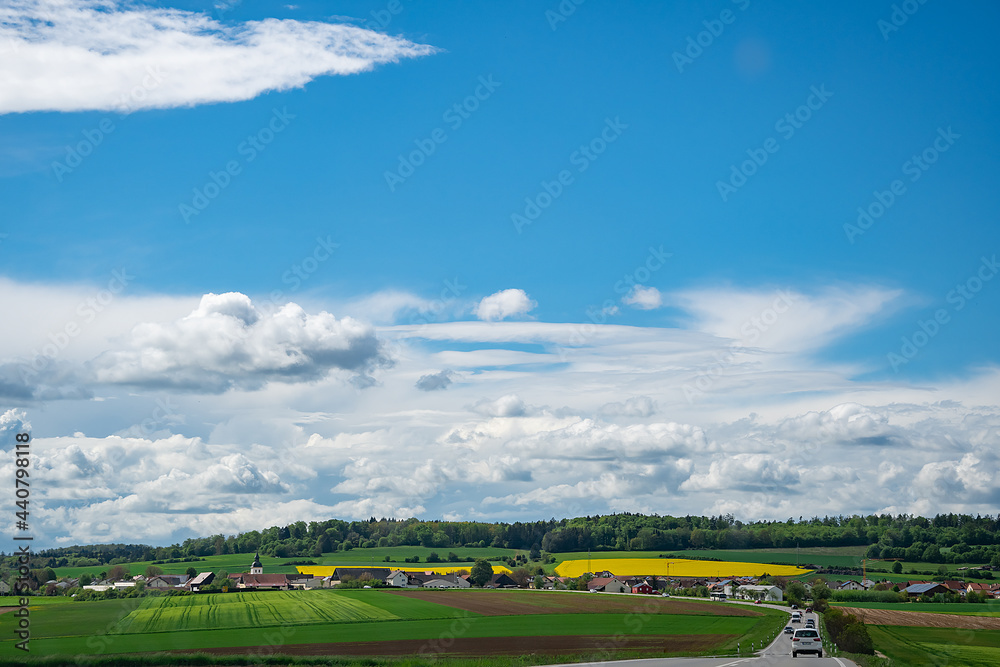 Obraz premium rapeseed field in bavaria, beautiful clouds on a summer day