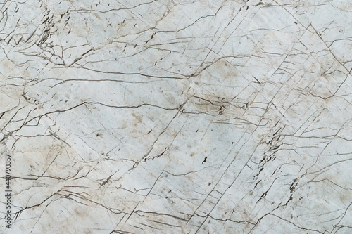 The texture of cracked white gray marble floor surface. Top view of a broken wall.