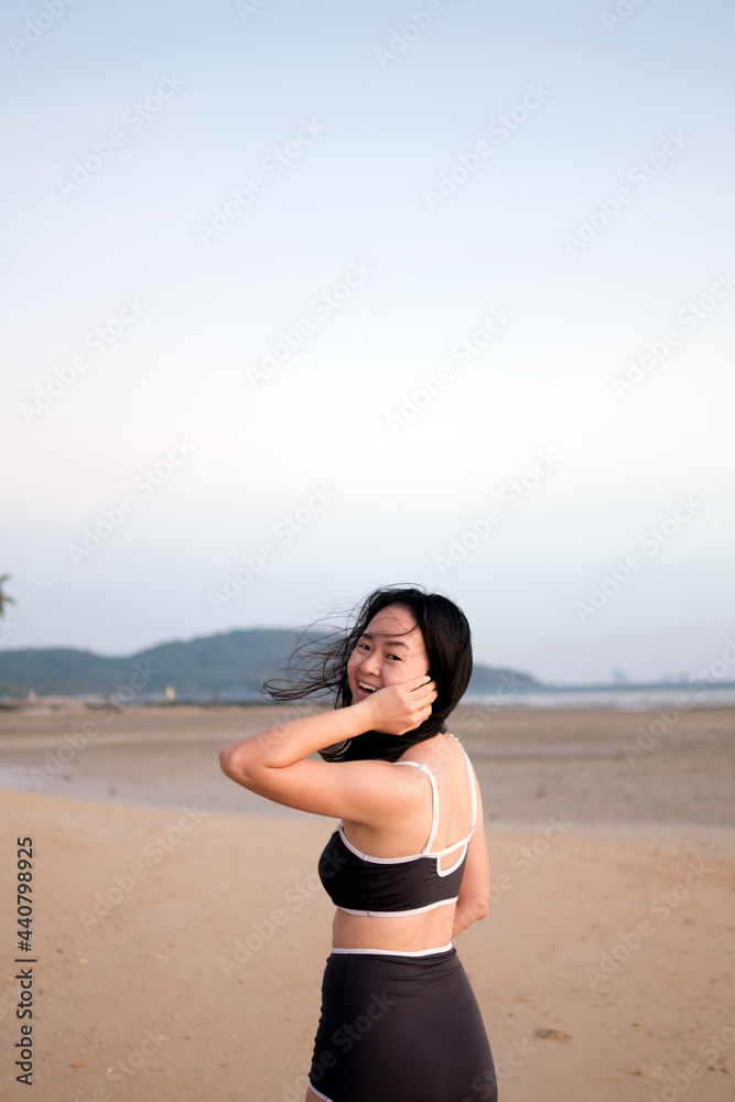 Woman teenager girl in bikini swimwear is relaxing on the sea beach at sunset holiday for happiness lifestyle concept Woman teenager girl in bikini swimwear is relaxing on the sea beach at sunset holiday for happiness lifestyle concept