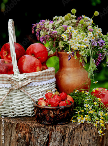 apples in a basket and a bouquet of flowers