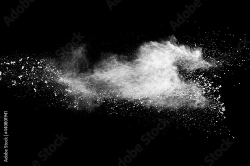 White dust particles splashing. Freez motion of talcum powder burst in dark background.