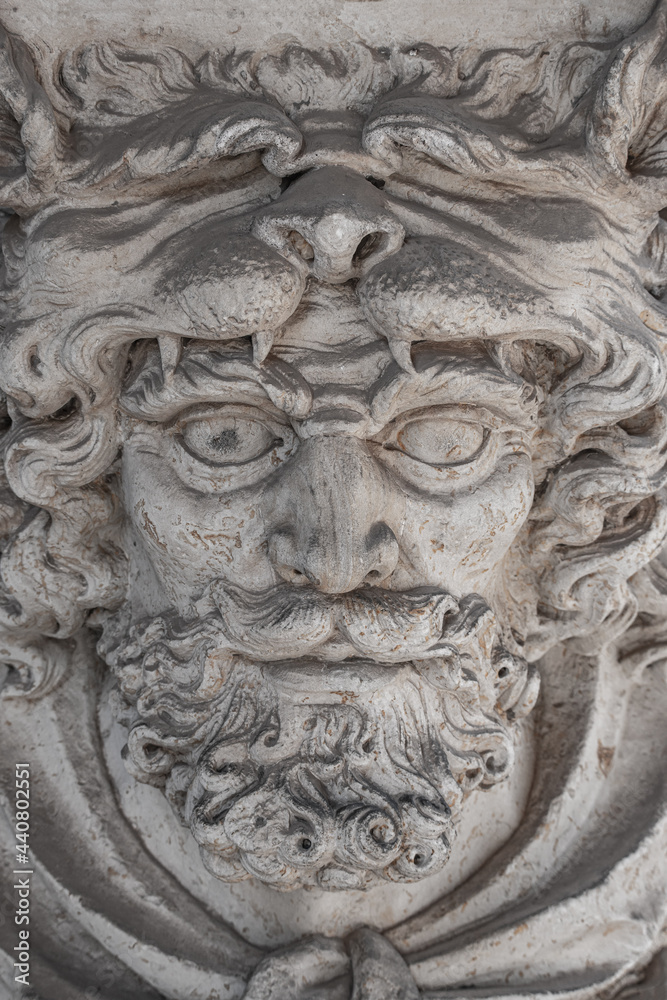 Bas-relief of an old sculpture of scary mythical worrier with leopard skin at his head as a gatekeeper in historical downtown of Dresden. Concept of art and historical heritage.