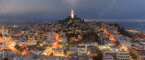 Coit Tower lit in pink for San Francisco LGBT Pride, with foggy skies over Telegraph Hill and North Beach Districts