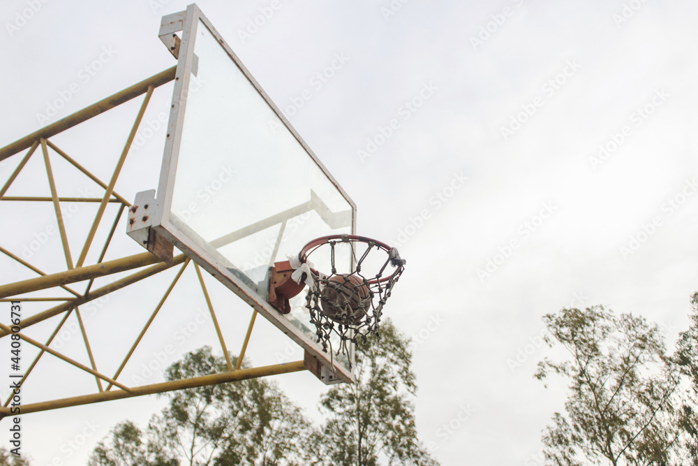 Basketball ball inside the hoop, in an abandoned court. Basketball ball inside the hoop, in an abandoned court.