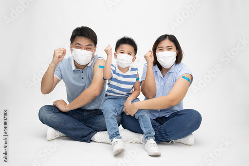 Asian family wearing white face mask and showing arm with plaster of covid-19 va Fototapeta