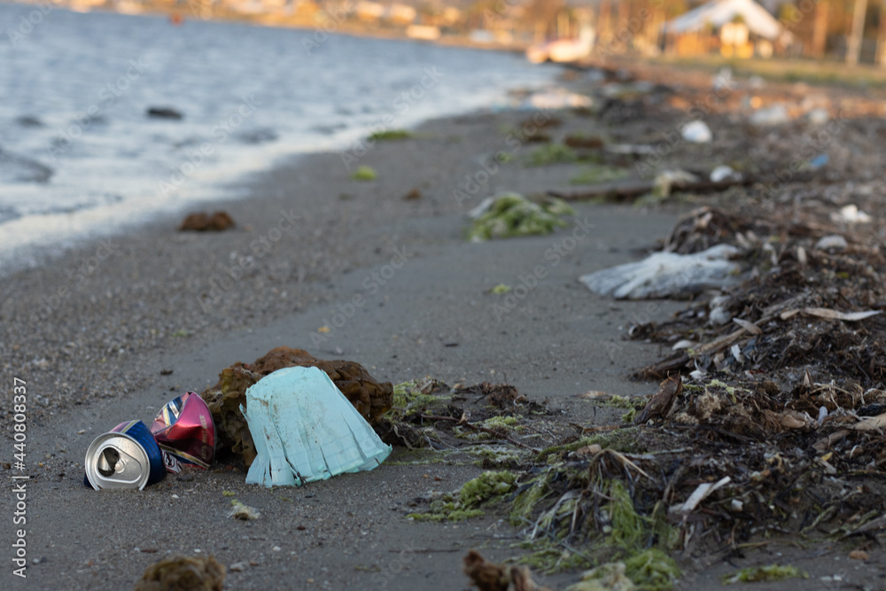 Spilled garbage on the beach of the big city. Empty used dirty plastic bottles. Dirty sea sandy shore the Black Sea. Environmental pollution. Ecological problem Spilled garbage on the beach of the big city. Empty used dirty plastic bottles. Dirty sea sandy shore the Black Sea. Environmental pollution. Ecological problem
