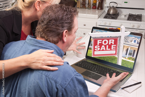 Couple In Kitchen Using Lap...