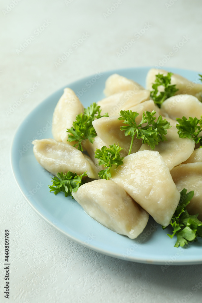 Concept of tasty food with vareniki or pierogi on white textured table Concept of tasty food with vareniki or pierogi on white textured table
