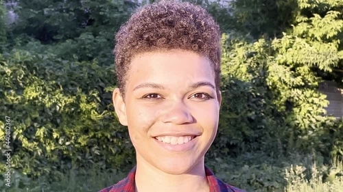 beautiful and happy African American woman with a short haircut in the summer on the street