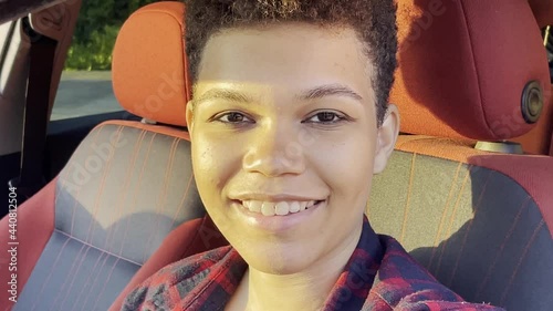 beautiful and happy African American woman with a short haircut in the summer on the street