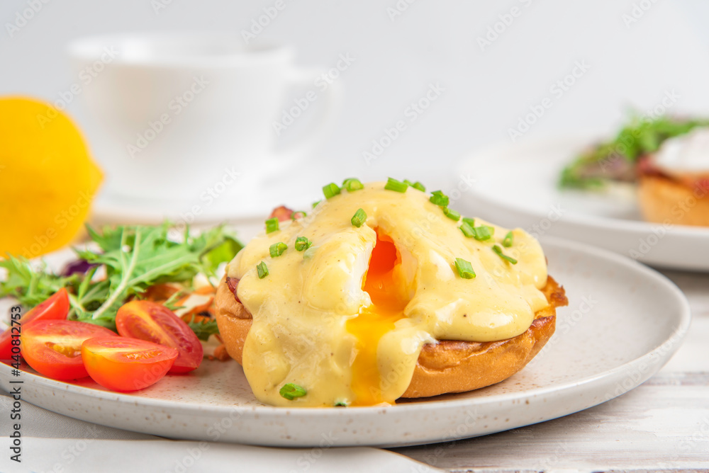 Eggs Benedict on toasted muffins with bacon. hollandaise sauce