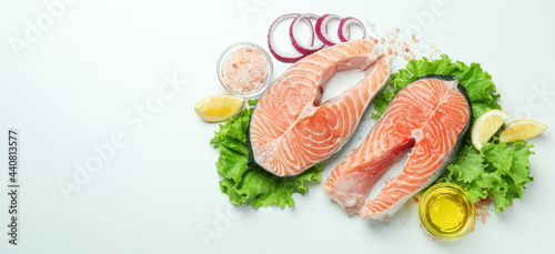 Fresh raw salmon and ingredients for cooking on white background