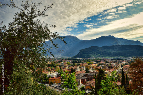 view from above to town Riva del Garda, mountains, buildings, lake Garda, Monte Brione, cloudy sky photo