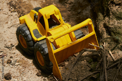 unbranded toy bulldozer, Unmarked toy bulldozer digging along a dirt wall
