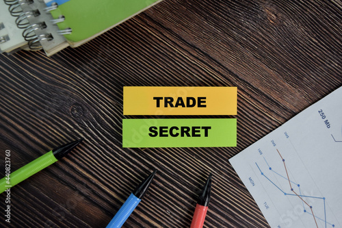 Trade Secret write on sticky notes isolated on Wooden Table. photo