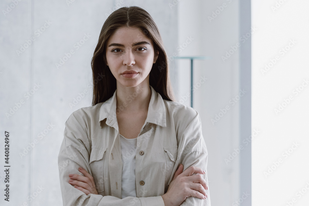 Young woman crossed hands on chest, looking at camera Young woman crossed hands on chest, looking at camera