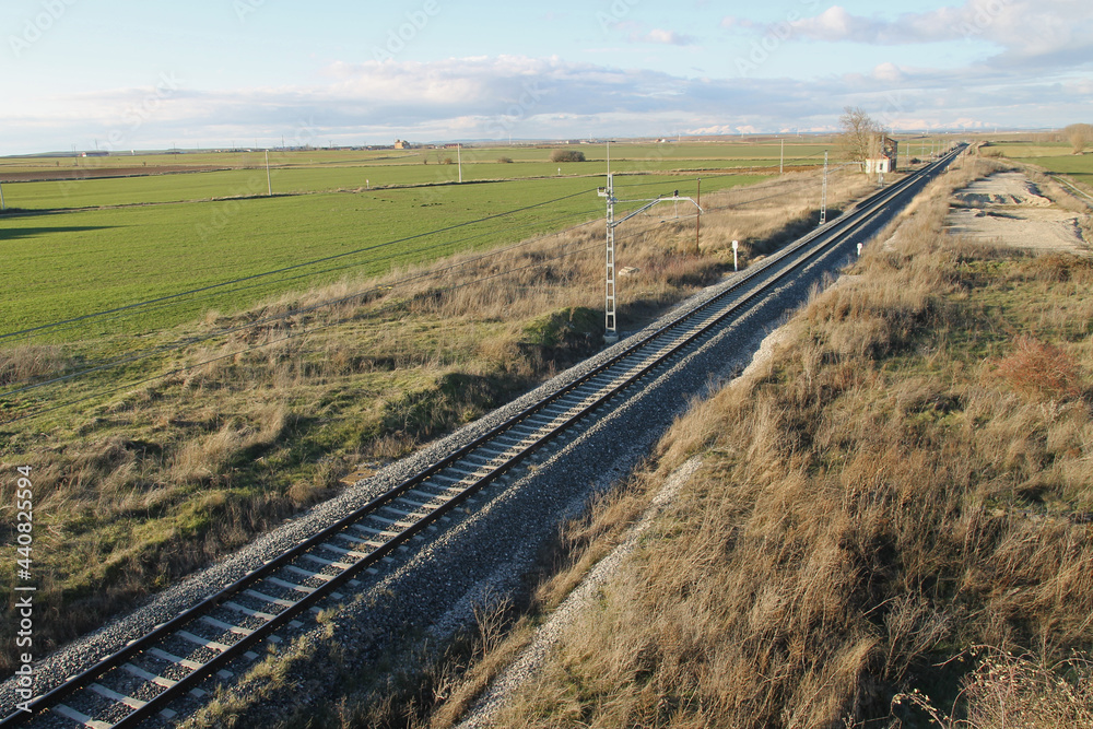The railroad track through the fields of Castilla near the town of Las Cabañas de Castilla, province of Palencia (Spain).