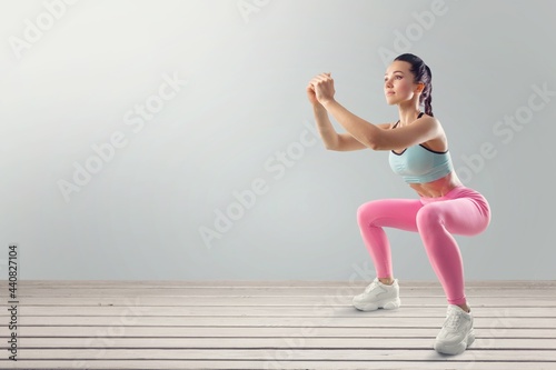 Fitness smiling woman in sports clothing do exercises