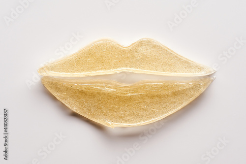 Transparent smear and texture of golden cosmetic gel on a white background.