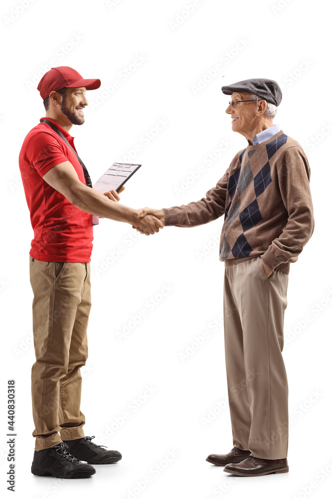 Fototapeta premium Full length profile shot of a delivery man shaking hands with a pensioner