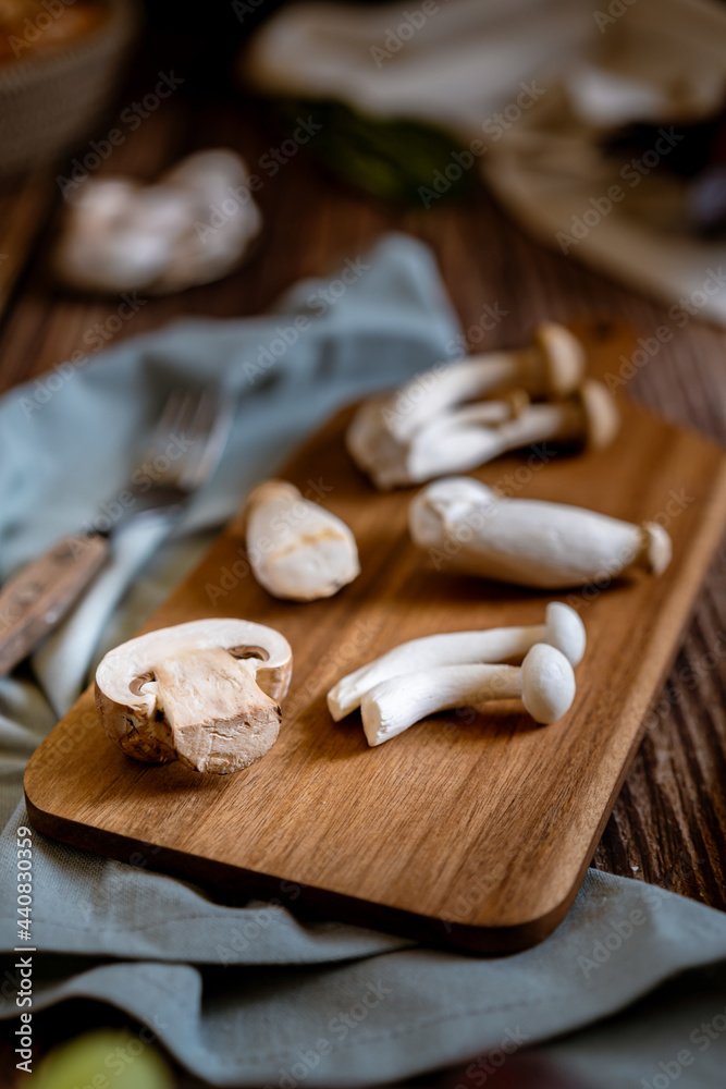 Dark photography of mushrooms, asparagus, bread, garlic and plums on a table of old wood. Vegetables recipe of for autumn or winter. Moody picture of seasonal cultivated fungus on a wooden table. Dark photography of mushrooms, asparagus, bread, garlic and plums on a table of old wood. Vegetables recipe of for autumn or winter. Moody picture of seasonal cultivated fungus on a wooden table.