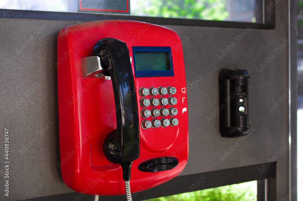 Telephone booth close-up. Red payphone on the street Telephone booth close-up. Red payphone on the street