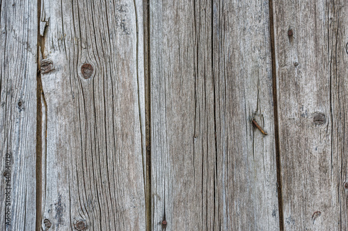 Old wooden fence gray-brown boards with cracked. Beautiful textured background for design.Old Vintage Rough Wood Bars Fence Texture Background.