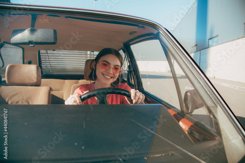 Girl wearing sunglasses sitting behind the wheel in the driver's seat © Yakobchuk Olena