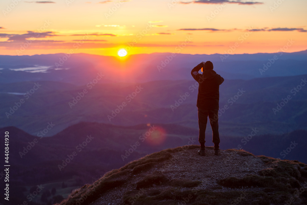 Man in top of mountain photographing the beautiful landscape at sunrise