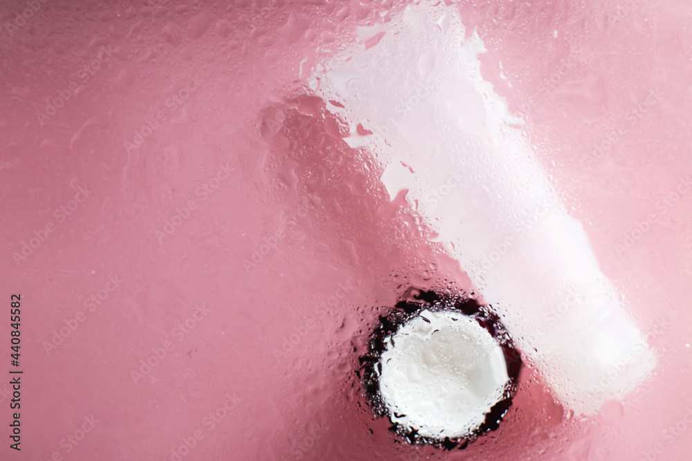 Fototapeta premium natural moisturizing skin care products. Face and hand cream under a glass surface with water on a pink background