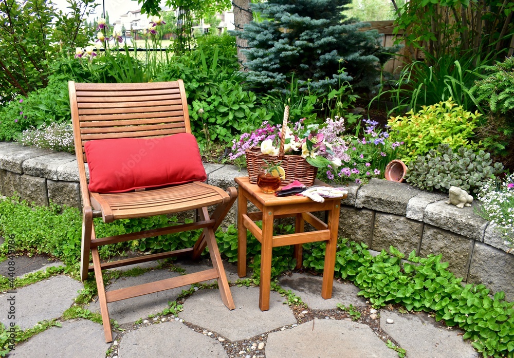 Obraz premium Backyard garden oasis with beautiful bouquet of seasonal cut flowers and glass of ice tea beverage for relaxing and enjoying secluded quiet time on warm summer afternoon staycations