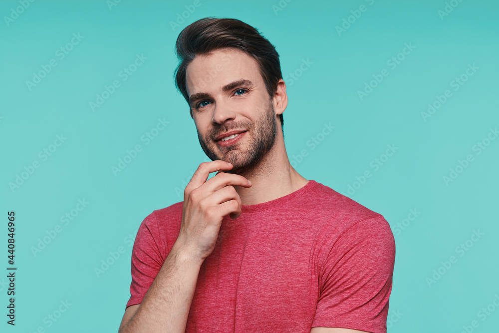 Portrait of handsome young man in casual wear holding hand on chin and smiling Portrait of handsome young man in casual wear holding hand on chin and smiling