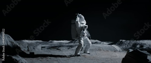 Male astronaut performing moonwalk dance move on a Moon surface. Shot with 2x anamorphic lens photo
