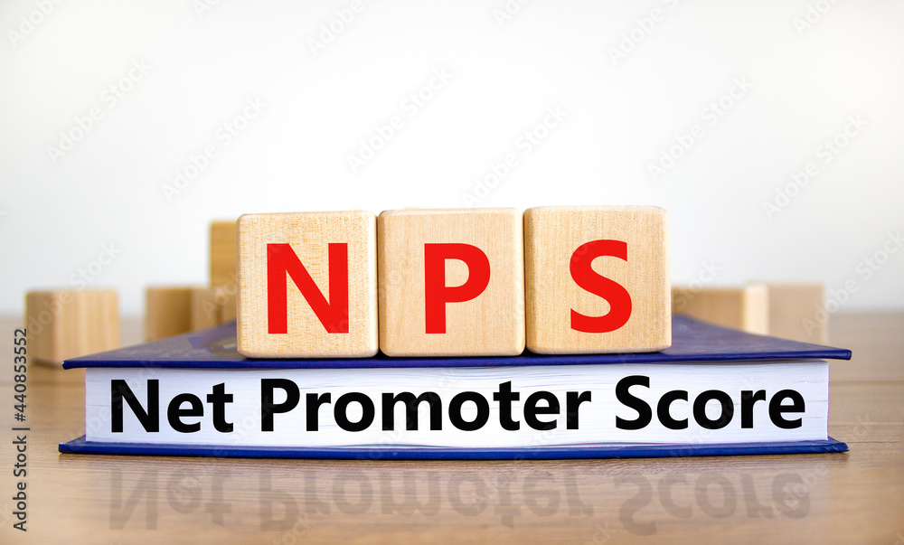 NPS net promoter score symbol. Wooden cubes on book with words 'NPS net promoter score'. White background. Business and NPS net promoter score concept. Copy space.